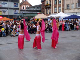 Drei Tänzerinnen tanzen während der interkulturellen Woche in Fulda. Im Hintergrund viele Zuschauer.