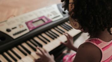 Ein Mädchen spielt auf einem Keyboard.