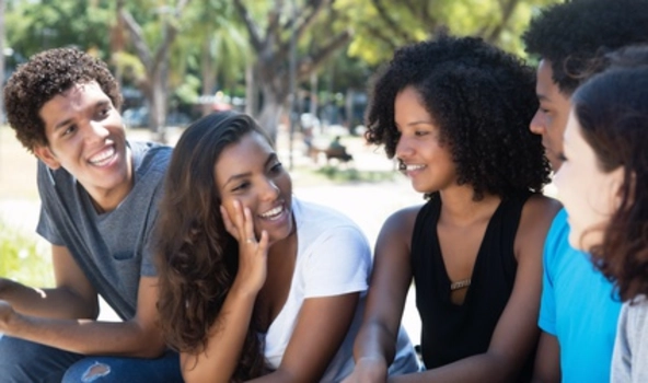5 Personen sitzen in einem Park und unterhalten sich.