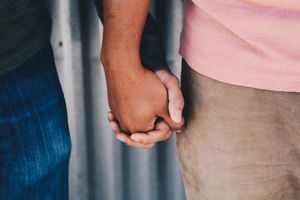 Ein Paar steht Hand in Hand nebeneinander.