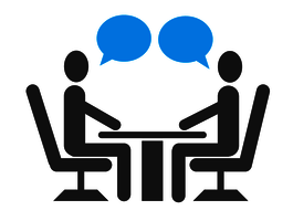 Piktogramm von 2 Menschen mit Sprechblasen. Sie sitzen sich an einem Tisch gegenüber und sprechen miteinander. 