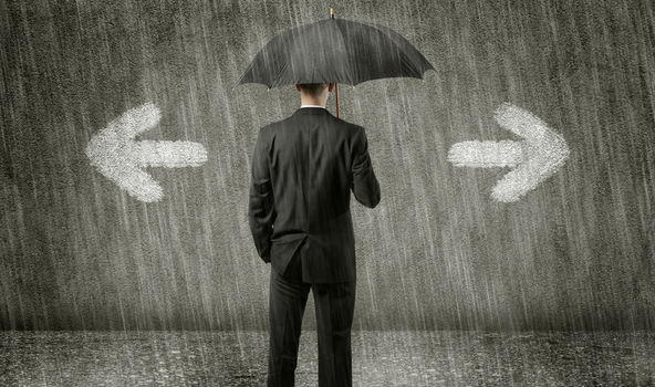 Schwarz gekleideter Mann steht mit dem Rücken zur Kamera unter einem scharzen Regenschirm. Sehr viel Regen fällt. Der Hintergrund ist schwarz und grau. Ein Pfeil nach links und ein Pfeil nach rechts sind neben dem Mann abgebildet. Es sieht aus, als ob sich der Mann entscheiden muss, in welche Richtung er gehen möchte.