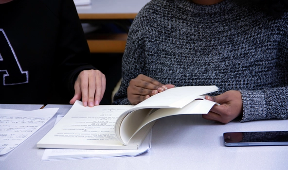 Zwei Schüler schauen sich ein Übungsheft an