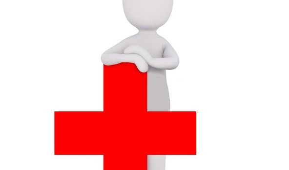 grafische Darstellung einer Person, die eine Krankenschwesterhaube auf dem Kopf trägt. Sie ist lehnt an einem roten Kreuz. 